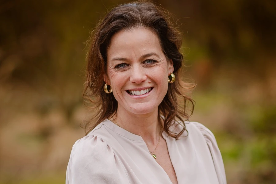 middle aged woman in beige top smiling